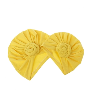 Close-up of two yellow baby turban hats with stylish handmade flower knot design