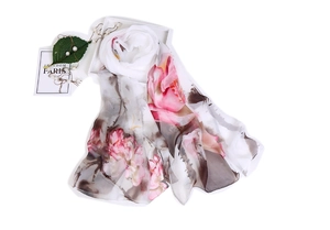 Detailed close-up of a long silk scarf with ink lotus floral patterns on a white tray