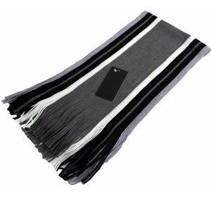 Close-up of thick striped winter scarf with grey, black, and white knit and fringes