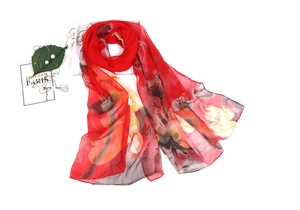 Detail of red floral chiffon scarf with elegant ink wash patterns and soft texture