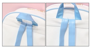 Detail of white PU leather backpack with sky blue trim, showing top handle and strap stitching