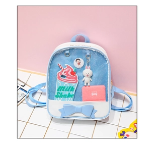 Detail of blue ita bag with transparent window showing bunny plush and cute badges