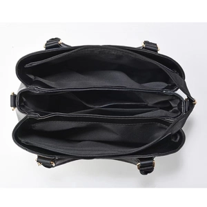 Vue de dessus du sac en cuir noir avec intérieur à trois compartiments et zips dorés
