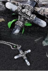 Macro detail of gothic skull cross pendant with resin texture on black sand