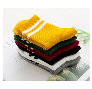 Detailed stack of six colorful cotton crew socks with white stripes on a book