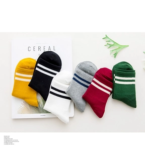 Flat lay of cotton crew socks in six colors with sporty double stripes and lifestyle props