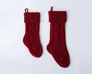 Close-up of red knitted Christmas stockings with classic diamond pattern and hanging loops