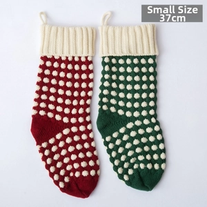 Détail de chaussettes de Noël en tricot rouge et vert avec pois blancs et boucle de suspension