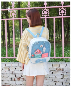 Detail of light blue ita-bag with clear display window, bow accent, and milk charm