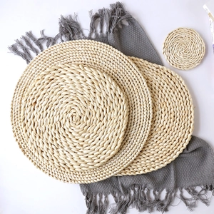 Handwoven natural corn husk round placemats and coasters set in minimalist style