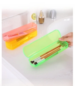 Detail of candy-colored portable toothbrush storage boxes in a marble bathroom setting