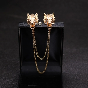 Close-up of golden wolf head brooch with double layer chains on a black jewelry box