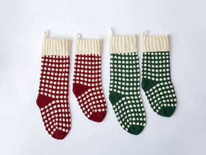 Détail de chaussettes de Noël tricotées rouges et vertes avec texture à pois en relief