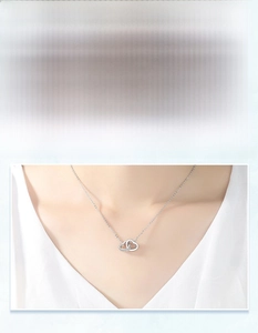 Detail view of S925 silver interlocking heart necklace with zircon inlay on model