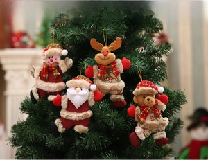 Detailed view of plush Christmas tree ornaments including snowman and reindeer hanging on pine