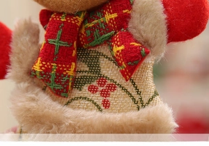 Detail of Christmas tree plush doll featuring red velvet and burlap fabric texture