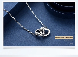 Detailed macro of S925 silver double heart pendant with micro-inlaid stones and O-chain