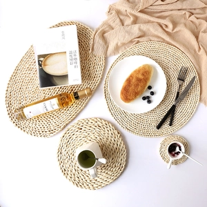 Set of four handmade natural corn husk woven placemats in round and oval shapes