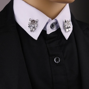 Close-up of silver wolf head collar pins with hanging chains on white shirt collar
