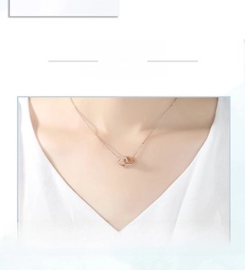 Detail of rose gold double heart pendant necklace with shimmering crystals on model