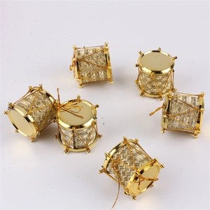 Close-up of six gold drum Christmas tree ornaments with festive metallic finish and hanging strings