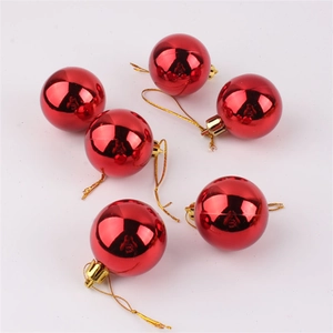 Close-up of vibrant red glossy Christmas ball ornaments with golden caps and hanging strings