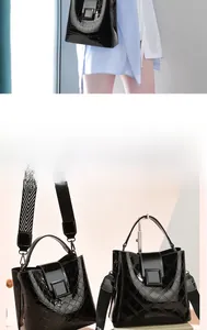 Detail of glossy black bucket bag featuring quilted textures and wide patterned strap