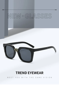 Detail of square black sunglasses featuring golden trapezoid metal bridge decoration