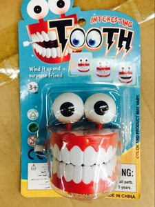 Close-up of wind-up chattering teeth toy in blister card packaging with English labels