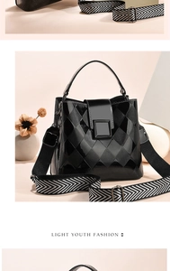 Detail of black patent leather bucket bag with quilted patterns and wide geometric strap