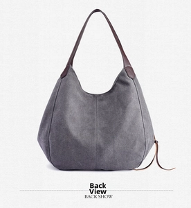 Detailed back view of grey canvas tote bag with brown handles and side drawstring accent