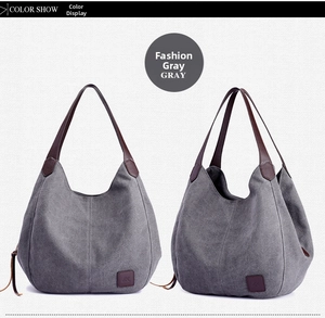 Detail view of grey canvas hobo tote bag with multiple compartments and leather handles