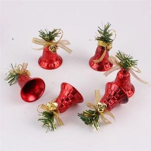 Detail view of red Christmas bell ornaments with golden bows and green pine needle accents