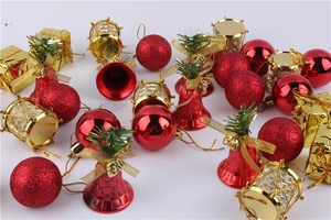 Flat lay of red and gold Christmas ornaments including glitter balls and mini gift boxes