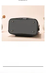 Detail of the bucket bag bottom featuring protective metal rivets and quilted side texture