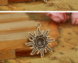 Macro shot of bronze sun pendant with wavy rays and vintage map background