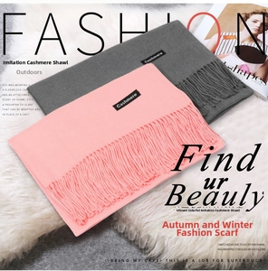 Close-up of pink and grey brushed cashmere scarves with tassels and sewn-on labels