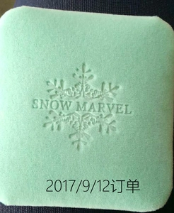 Detail of mint green velvet jewelry box featuring an embossed snowflake and logo design