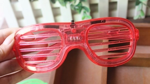 Detail of red shutter LED glasses showing the battery compartment and power switch