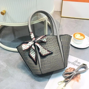 Detail of grey crocodile texture tote bag with printed silk scarf and leather strap