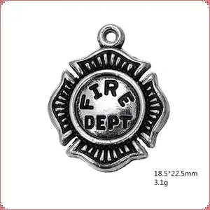 Macro shot of antique silver firefighter pendant with Fire Dept Maltese Cross design