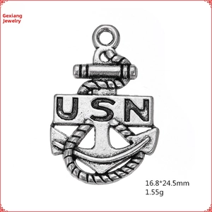 Macro detail of antique silver USN anchor pendant with intricate rope texture and ring