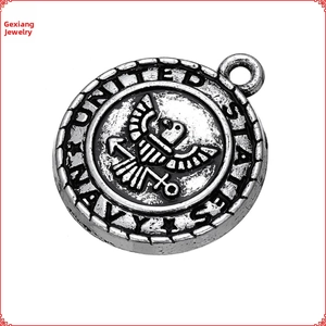 Detailed close-up of antique silver United States Navy eagle and anchor crest pendant