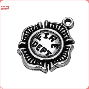 Macro detail of a vintage silver fire department emblem pendant with embossed texture