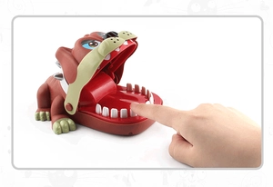 Close-up of hand pressing teeth mechanism on bulldog biting finger prank toy