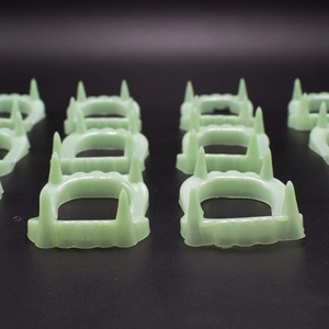 Macro shot of green glow-in-the-dark vampire fangs for Halloween prank props