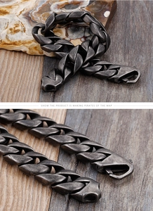 Gros plan d'un bracelet gourmette en acier inoxydable noir avec un fermoir vintage