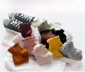 Detailed macro shot of frilly edge cotton socks in various warm autumn colors