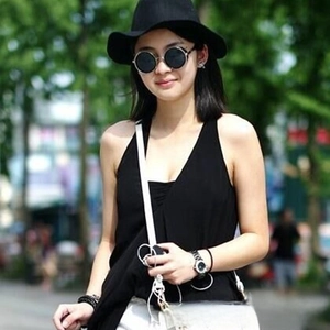 Close-up of retro round metal sunglasses with black lenses on a fashion model