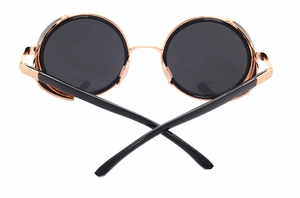 Close-up of golden steampunk sunglasses featuring round grey lenses and metal side shields